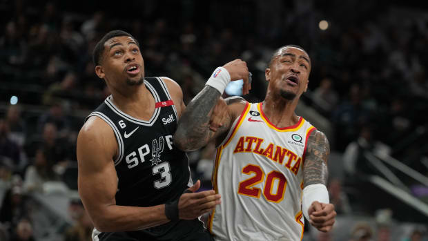 San Antonio Spurs forward Keldon Johnson and Atlanta Hawks forward John Collins battle for a rebound.